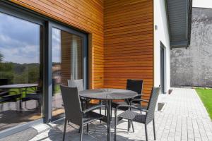 a patio with a table and chairs on a balcony at Staufenberg Chalets in Berschweiler