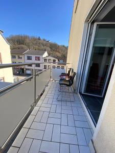 a balcony with a chair on a building at Moderne 2 Zimmer Wohnung Küche und Bad im Zentrum in Merzig