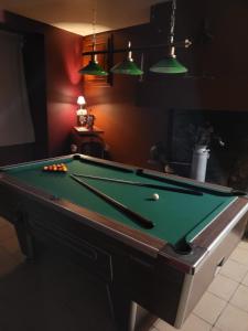 a pool table in a living room with afits at L'Aurigast in Auriac-Lagast