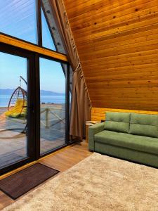 a living room with a couch and a view of the ocean at Son-Kul A-Frame & Yurt Camp in Song-Kul