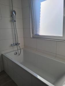 a bath tub with a shower in a bathroom at Monstera Apartment in Groß-Umstadt