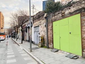 a green door on the side of a brick building at Green Door Hostel in Tirana
