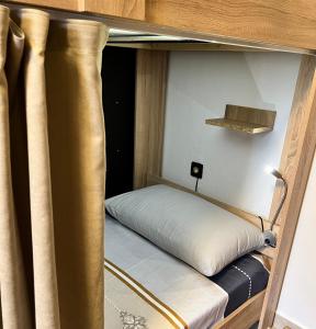 a small bed in a bunk bed room at Green Door Hostel in Tirana