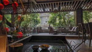 a patio with a large window and a table and chairs at Shishe Spring Designer Homestay in Dujiangyan
