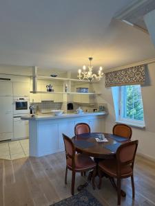 a kitchen with a table and chairs and a kitchen with a counter at Klostergarten in Einsiedeln