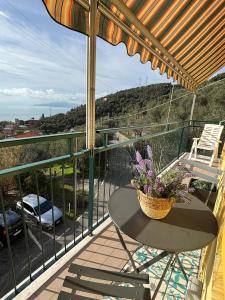 a balcony with a table and a basket of flowers at Casa Mina in Lavagna