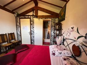 a bedroom with a red bed in a room at Maison d'Hôtes L'Escale Du Loup Blanc in Maringes +17 photos