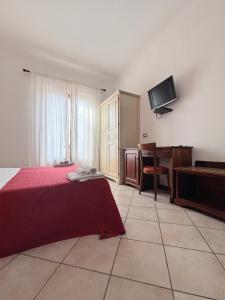 a bedroom with a bed and a desk and a television at Mamamia #Lipari in Lipari