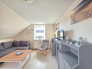 a living room with a couch and a table at Ferienwohnung Strandbrise in Dornum