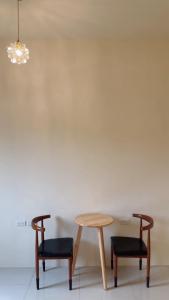 two chairs and a table in a room at Grass in the Wind B&B in Magong