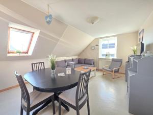 a dining room and living room with a table and chairs at Ferienwohnung Strandbrise in Dornum +23 photos