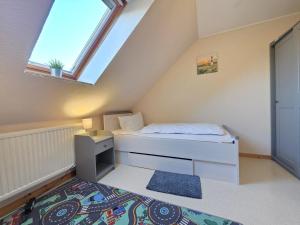 a small bedroom with a bed and a window at Ferienwohnung Strandbrise in Dornum