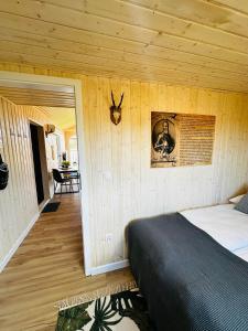 a bedroom with a bed in a wooden wall at Osada Rycerska & Apartamenty Rycerskie in Inowłódz