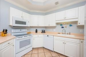 a kitchen with white cabinets and white appliances at Phoenix on the Bay 1122 condo in Orange Beach