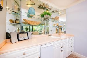 a kitchen with a sink and a mirror at Phoenix on the Bay 1122 condo in Orange Beach