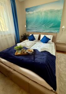 a bed with a tray of food on it at Remora Apartman Balatonszemes in Balatonszemes