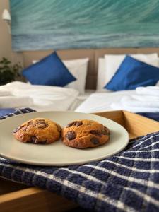 two chocolate chip cookies on a plate on a bed at Remora Apartman Balatonszemes in Balatonszemes