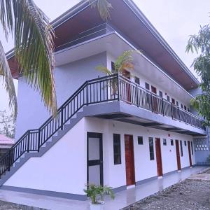 a white house with a staircase on it at MartiVille Residences in Gloria