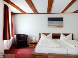 a hotel room with a bed and a chair at Hotel Zum Schwarzen Walfisch in Bad Säckingen +22 photos