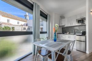 a kitchen with a table and chairs and a large window at River Corner - Centro Ayamonte in Ayamonte