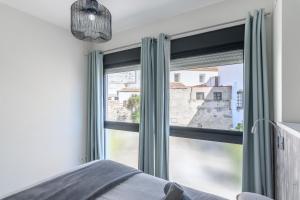 a bedroom with a window with green curtains at River Corner - Centro Ayamonte in Ayamonte