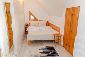 a bedroom with a bed and a chair and a window at Vila Daiana- Acceptam vouchere vacanta in Moieciu de Jos