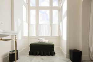une pièce avec un pouf devant une fenêtre dans l'établissement La Villa Rosa, à Bruges