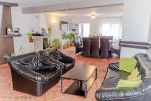 a living room with a leather couch and a table at Vila Daiana- Acceptam vouchere vacanta in Moieciu de Jos