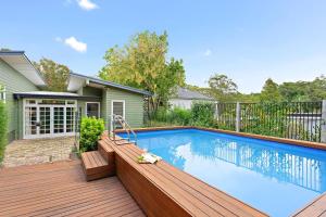 a swimming pool on a deck next to a house at Elegant 4BR Sanctuary with Private Pool in Warrawee