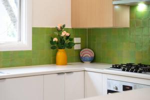 a kitchen with a yellow vase with flowers in it at Elegant 4BR Sanctuary with Private Pool in Warrawee +10 photos