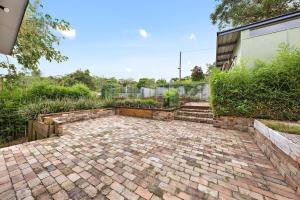 a brick patio in the backyard of a house at Elegant 4BR Sanctuary with Private Pool in Warrawee