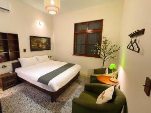 a bedroom with a bed and two green chairs at 光陰GUANGinn in Hsinchu City