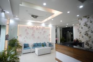 a living room with a couch and a wall with flowers at Frolic Hotel Near Sec 52 Noida Metro Station in Noida