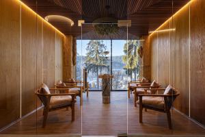 a restaurant with chairs and tables and a large window at Hotel Podgorie Spa in Bukovel