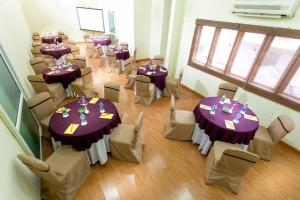 a room with tables and chairs with purple table cloth at HM Suites & Studios in Bangalore