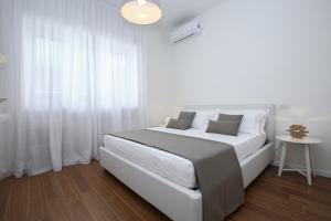 1 dormitorio blanco con 1 cama grande y cortinas blancas en Starhost - GOLDEN APARTMENTS, en Salerno