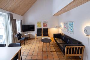 a living room with a couch and a tv at Skagen Strand Holiday Center in Hulsig