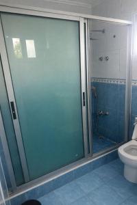 a glass shower door in a bathroom with a toilet at Vaidosa Guesthouse in Maputo +7 photos