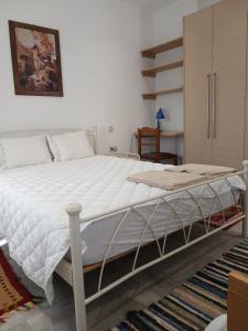 a bedroom with a large bed with white sheets at Ιχνηλάτες in Agios Nikolaos