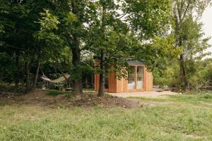 a house with a hammock hanging from a tree at Útulna Rychleby in Vápenná +8 photos