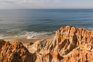 an aerial view of the ocean and a rocky beach at Falésia Hotel - Adults Only in Albufeira