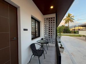 a balcony with two chairs and a table on it at Wanwichai Room in Ban Lam Ru (1)