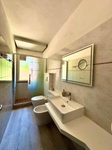 a bathroom with a sink and a toilet and a mirror at Casa Campanella Resort in Capoliveri +67 photos