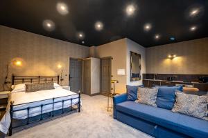 a bedroom with a bed and a blue couch at The Links Apartments in Newark-on-Trent