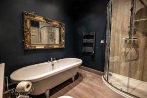 a bathroom with a bath tub and a mirror at The Links Apartments in Newark-on-Trent +38 photos