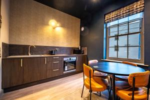 a kitchen with a table and chairs and a window at The Links Apartments in Newark-on-Trent