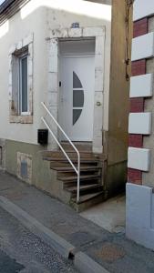 a white door with stairs in front of a building at Au 24 a connerre in Connerré