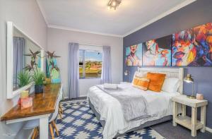 a bedroom with a bed and a large painting on the wall at Flip-Flop Flat in Langebaan