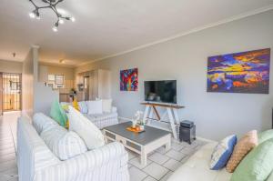 a living room with two white couches and a table at Flip-Flop Flat in Langebaan