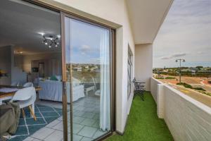 a room with a balcony with a view of the ocean at Flip-Flop Flat in Langebaan